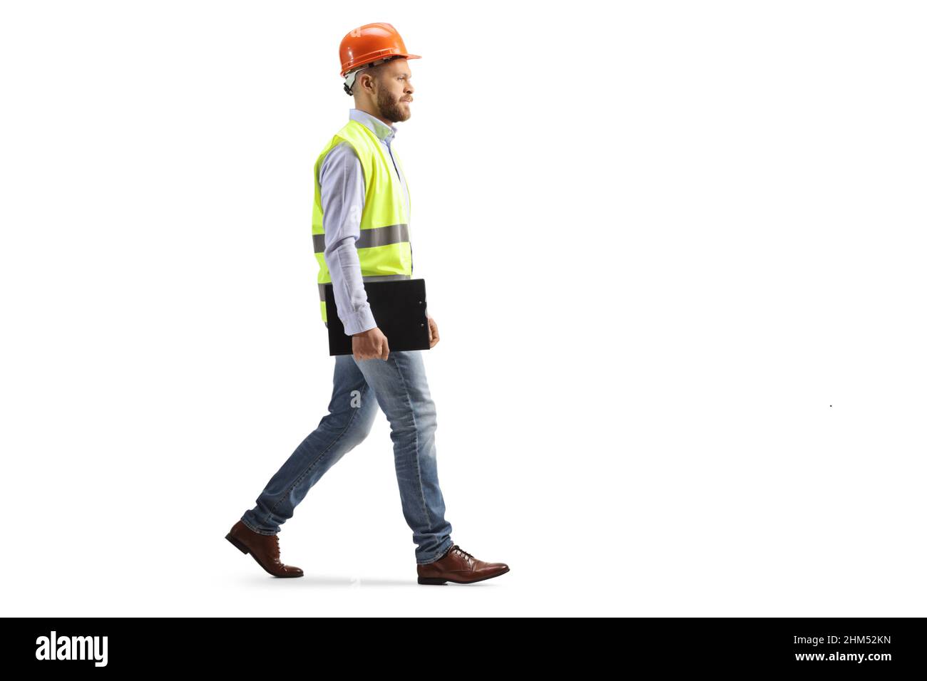 Ripresa di un ingegnere con un cappello a piedi e tenendo un portadocumenti isolato su sfondo bianco Foto Stock