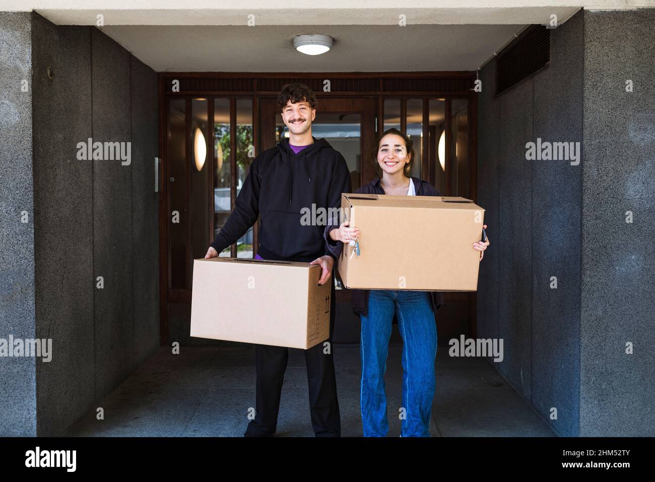 Ritratto di sorridenti coppie che trasportano scatole Foto Stock