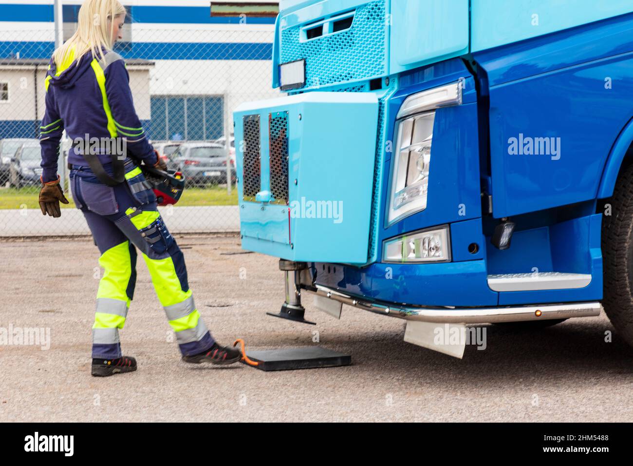 Donna che lavora in prossimità di un camion blu Foto Stock