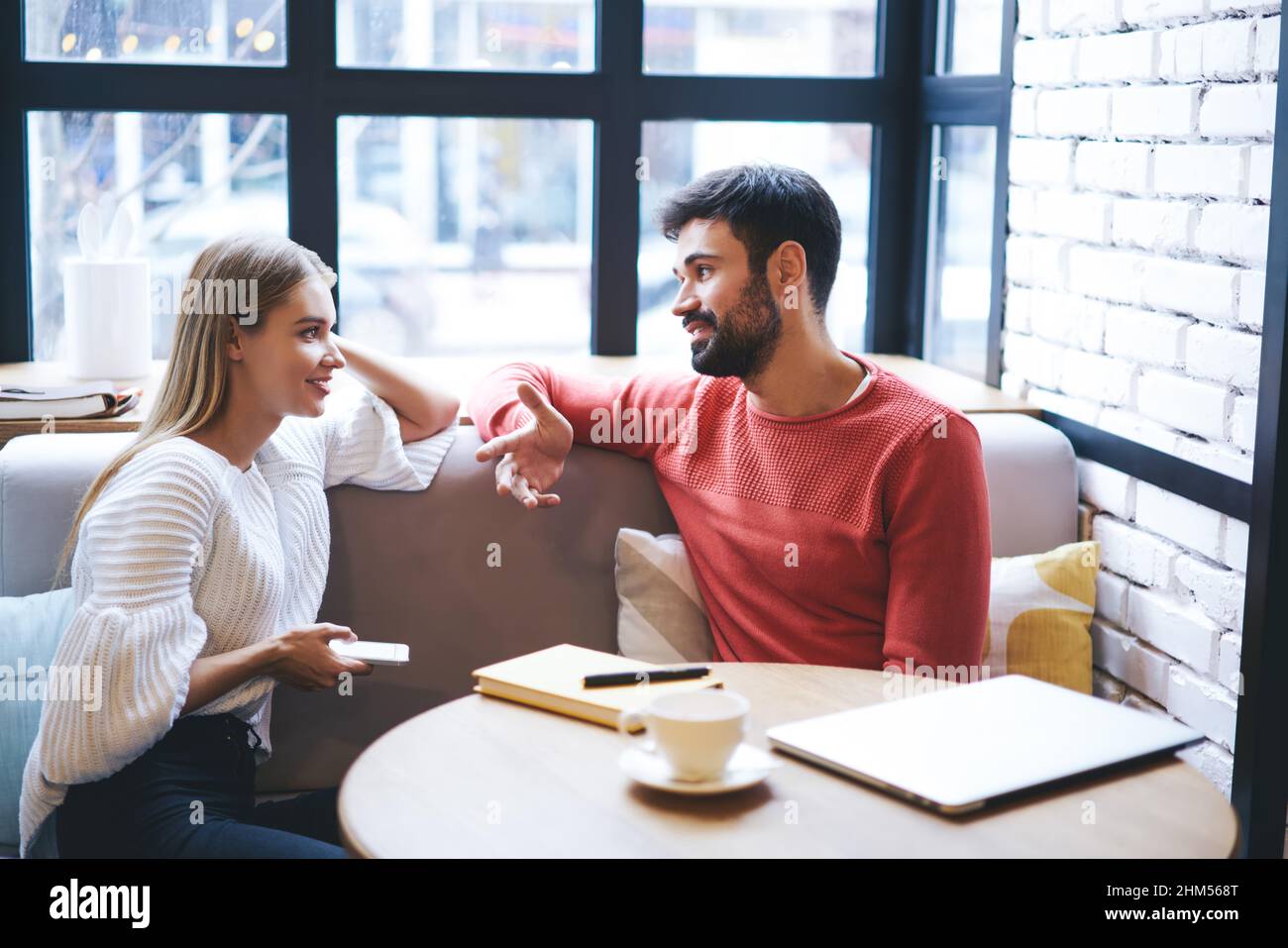 Il ragazzo e la signora sono molto positivi e discutono dei piani in un bar Foto Stock