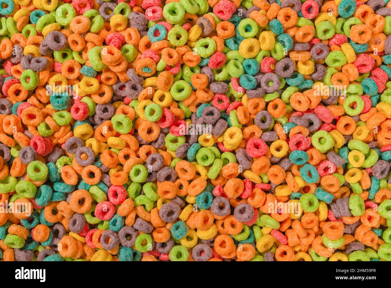 Dolci fiocchi multicolore, anelli di cereali come sfondo. Foto Stock