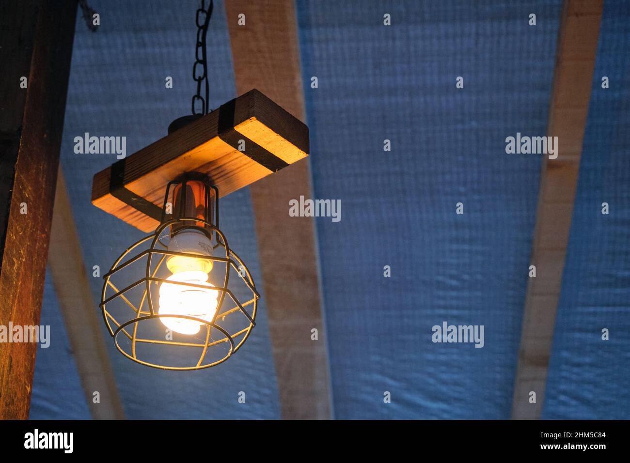 Lampada in stile vintage, lampada elettrica appesa a stab in legno. Foto Stock