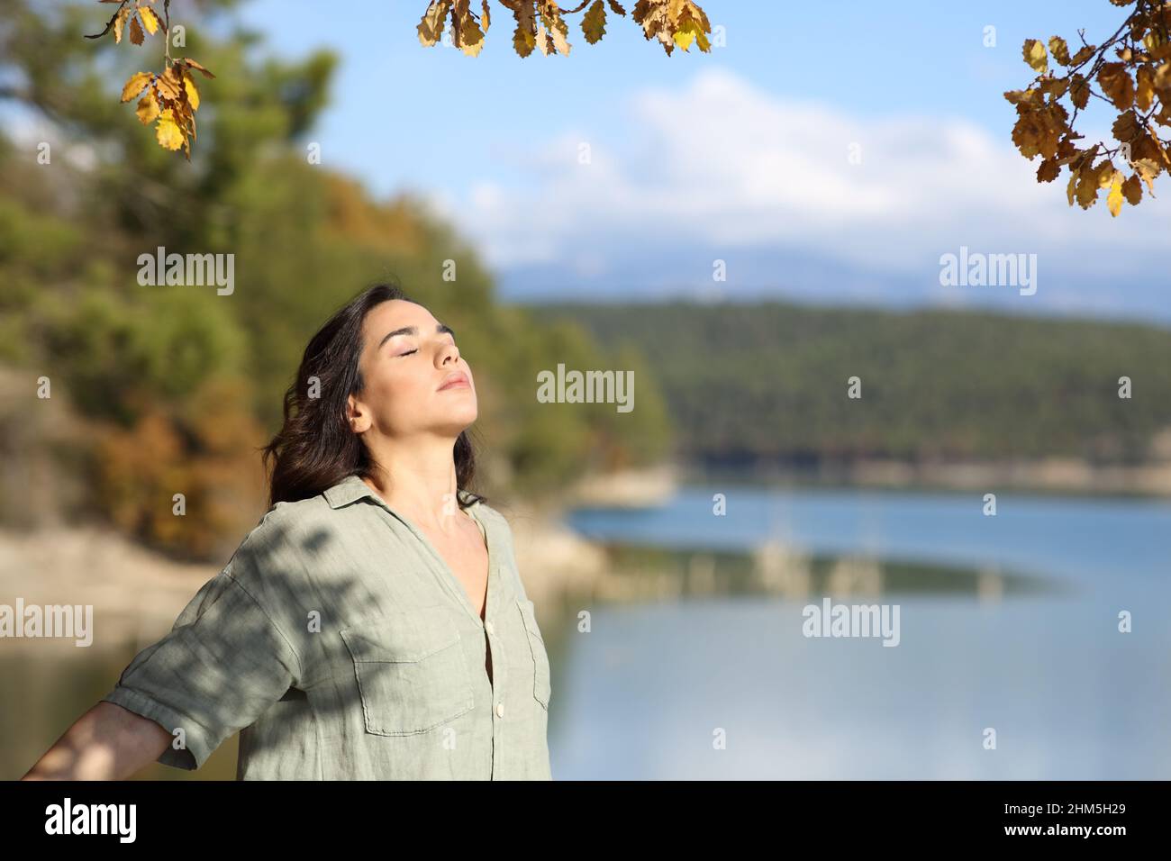 Donna respirare aria fresca rilassante in un lago in autunno Foto Stock