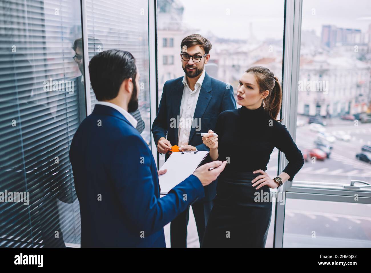 Gruppo di colleghi che discutono di business plan in ufficio Foto Stock