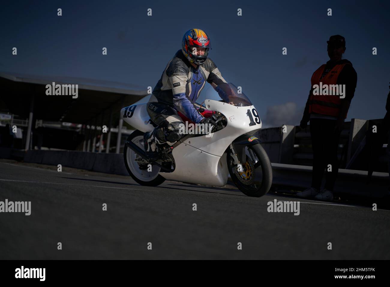 11-05-2021 riga, Lettonia bel pilota uomo con barba e baffi in pelle nera biker giacca e occhiali da sole si siedono su stile classico cafe racer motorc Foto Stock