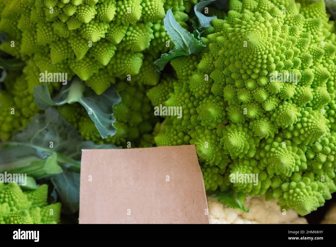 Romanesco broccoli per la vendita su un mercato. Romanesco broccoli, o cavolo romano vicino. Mercato ortofrutticolo. Verdure fresche in un cestello, compreso un cavolfiore e Broccolo romanesco. Foto Stock