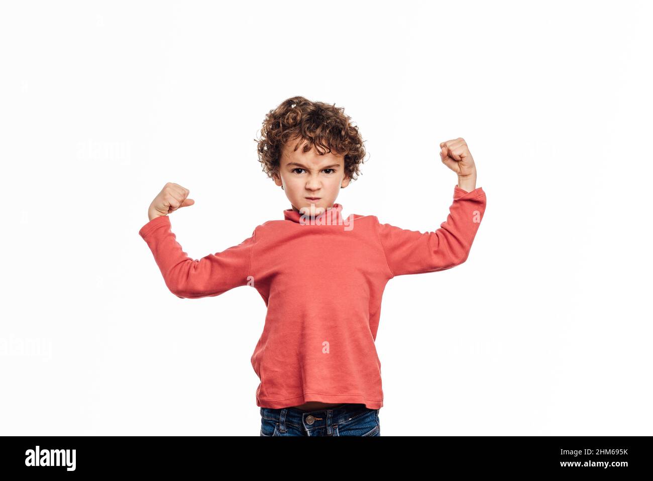 Ragazzo giovane arrabbiato che alza entrambe le braccia con pugni di pugni arrabbiati a mostrare la sua forza. Foto Stock