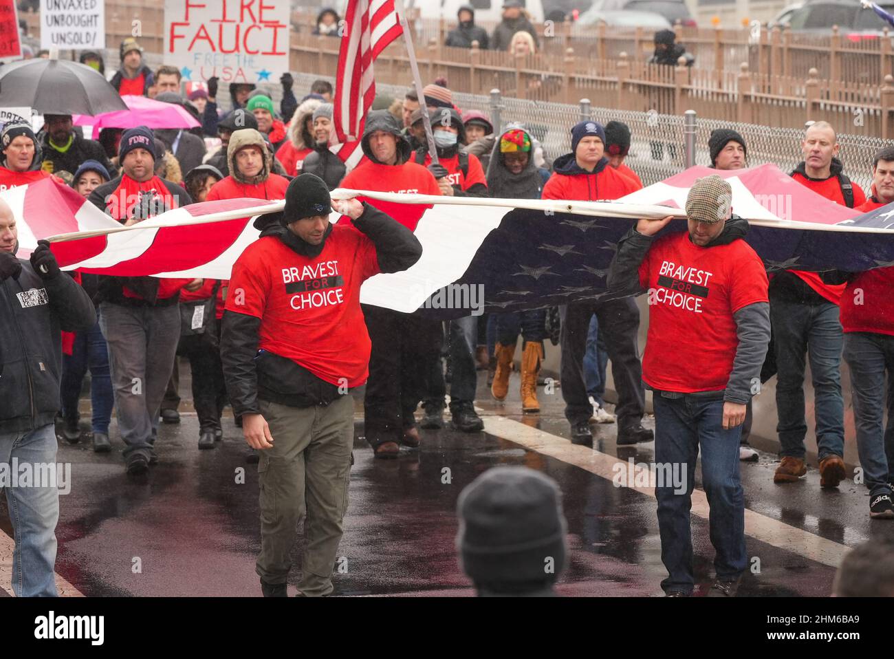 New York City, Stati Uniti. 07th Feb 2022. Durante la protesta, i manifestanti portano una bandiera statunitense.più di 300 lavoratori cittadini e altri hanno marciato oggi sul ponte di Brooklyn per protestare contro l'annuncio della città che i dipendenti municipali senza una vaccinazione Covid-19 sarebbero stati licenziati entro la fine della settimana. Credit: SOPA Images Limited/Alamy Live News Foto Stock