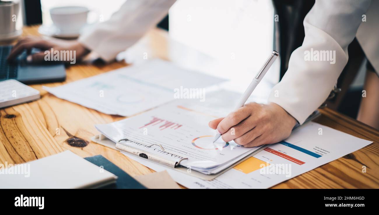 Primo piano mano di donna d'affari usa le calcolatrici di imposta ed il reddito dell'azienda. Conto, fondo finanziario investimento Consult concetto Foto Stock