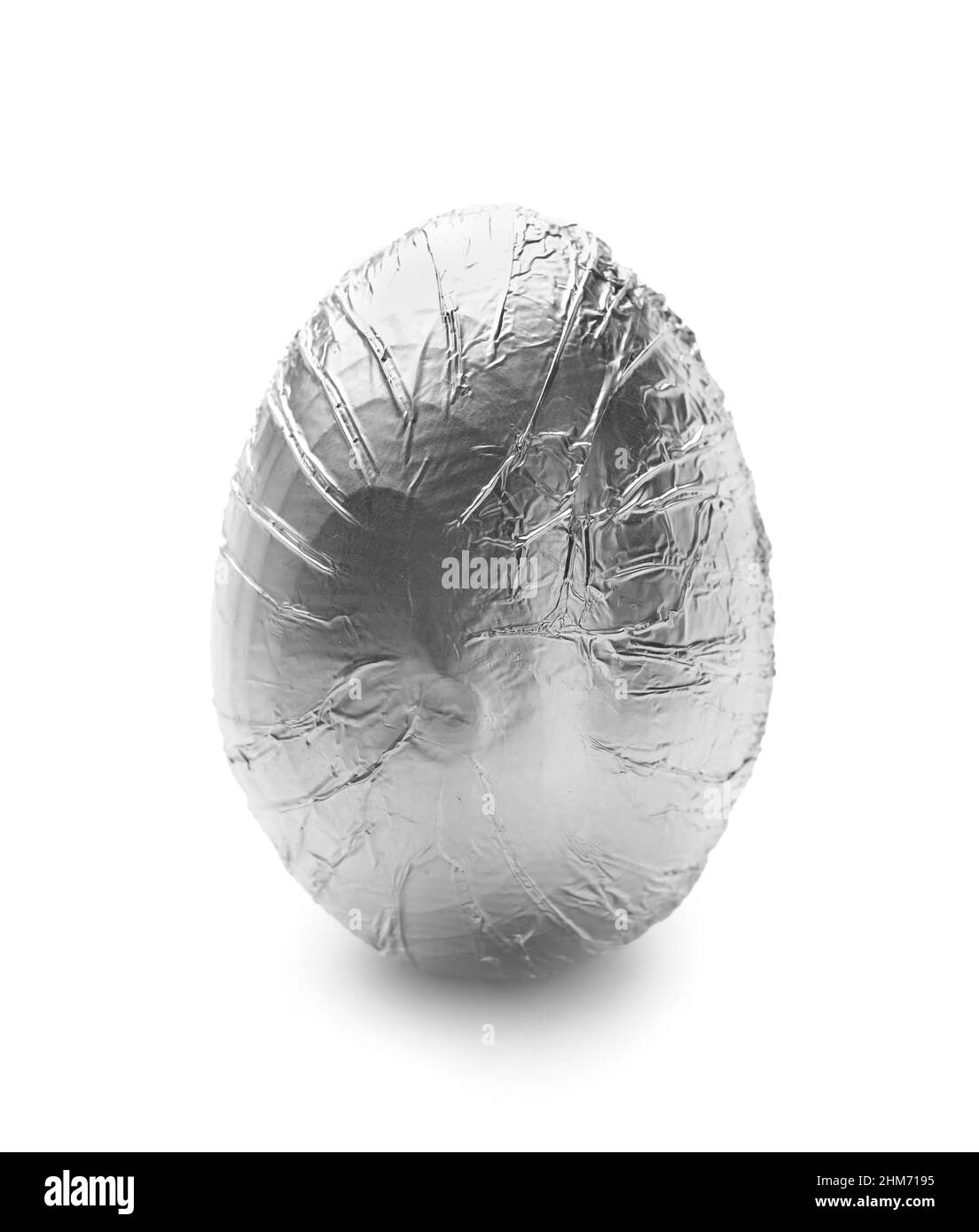 Uovo di Pasqua avvolto in lamina d'argento su sfondo bianco Foto Stock