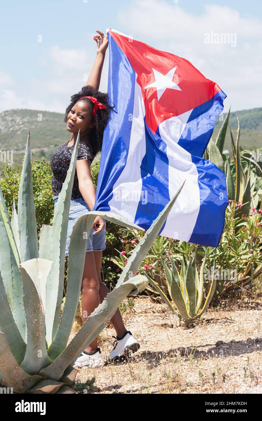 Vista di una donna che sventola una bandiera cubana Foto Stock