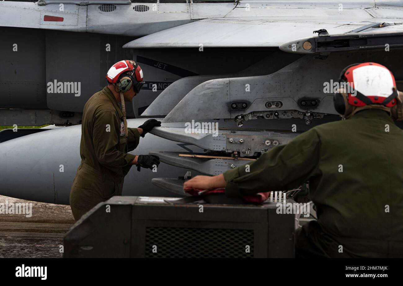 I Marines degli Stati Uniti assegnati allo Squadron 112 dell'attacco del combattimento marino preparano un F-18C Hornet per ricevere gli ordnances sulla base di aeronautica di Andersen, Guam, 28 gennaio 2022. Il Marine Aviation Logistics Squadron 12 e MFAS 112 hanno eseguito il carico di ordnance per mantenere gli standard di competenza e per la coesione di unità per le prossime esercitazioni. (Senior Airman Michael S. Murphy) Foto Stock