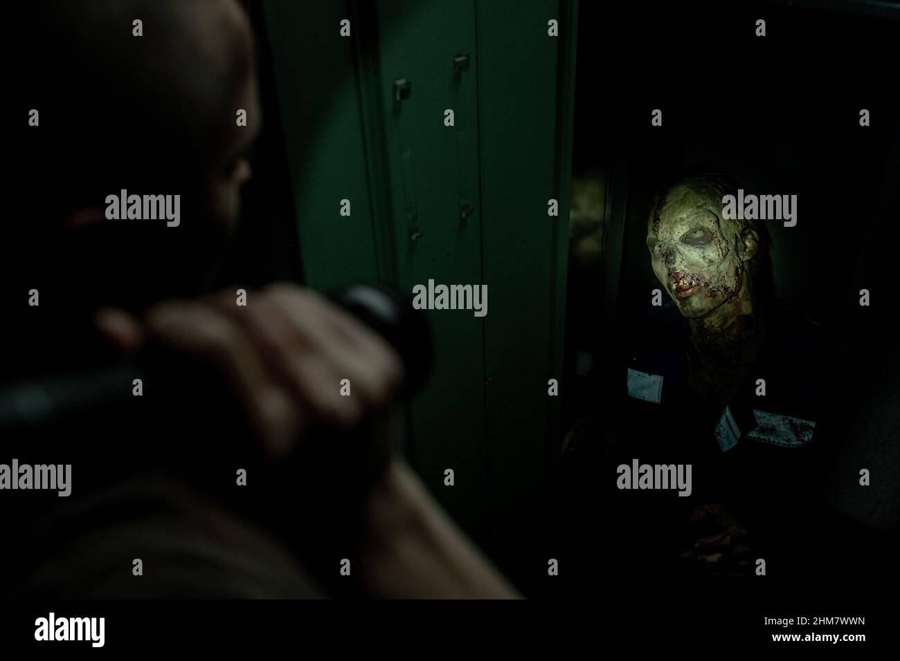 Scatto di orribile zombie volto catturato in torcia luce in angolo scuro, horror apocalypse e sopravvivenza concetto, copia spazio Foto Stock