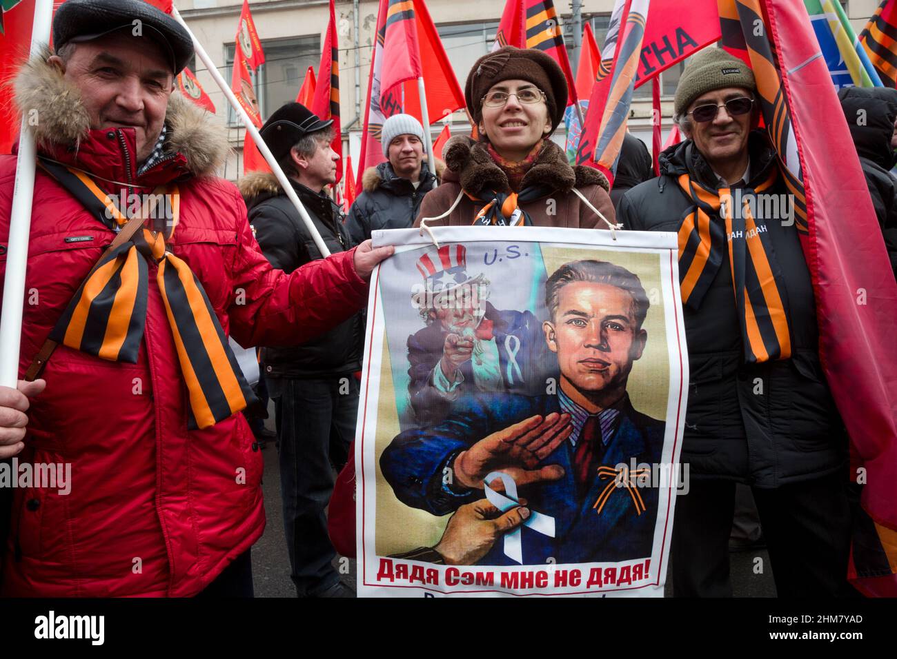 Mosca, Russia. 21st febbraio, 2015 persone hanno striscioni e bandiere durante la marcia di attivisti del movimento 'Anti-Maidan' (sostenitori Pro-Cremlino) nel giorno del primo anniversario degli eventi sanguinosi sulla Maidan in Ucraina nel centro di Mosca, Russia. Il banner recita: 'Zio Sam non è mio zio' Foto Stock