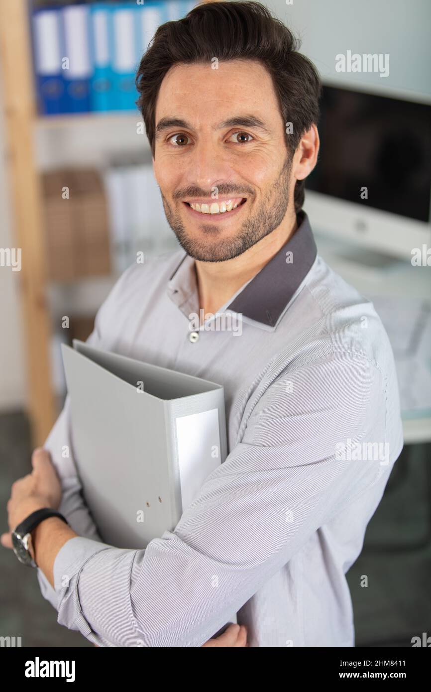 felice uomo d'affari con la cartella in ufficio Foto Stock