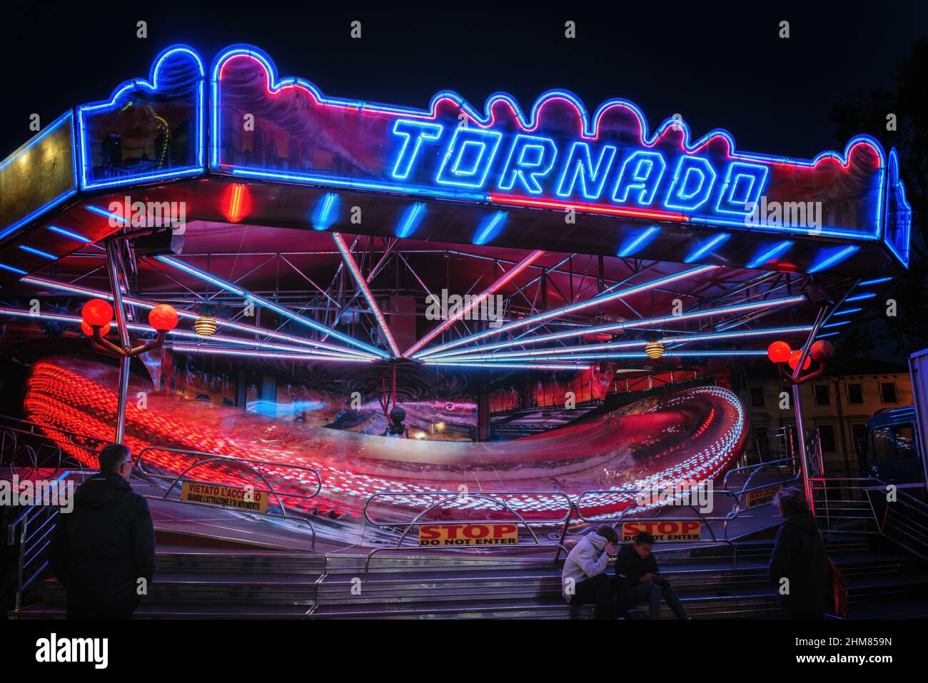 L'attrazione di Tornado corre nel buio. Luna Park attrazione. Fotografia a lunga esposizione. Foto Stock