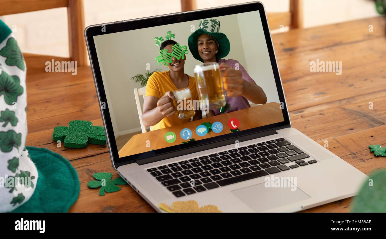 Webcam vista di due uomini afroamericani che tengono birre in videochiamata  sul portatile su un tavolo di legno Foto stock - Alamy
