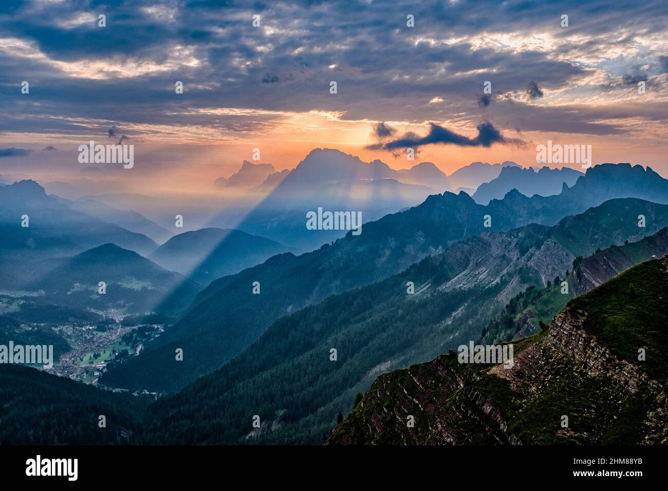 Creste dolomitiche e cime intorno a Falcade nella valle del Biois, Monte Pelmo (a sinistra) e Civetta in lontananza, visto dall'alto del Passo delle Valles al sole Foto Stock