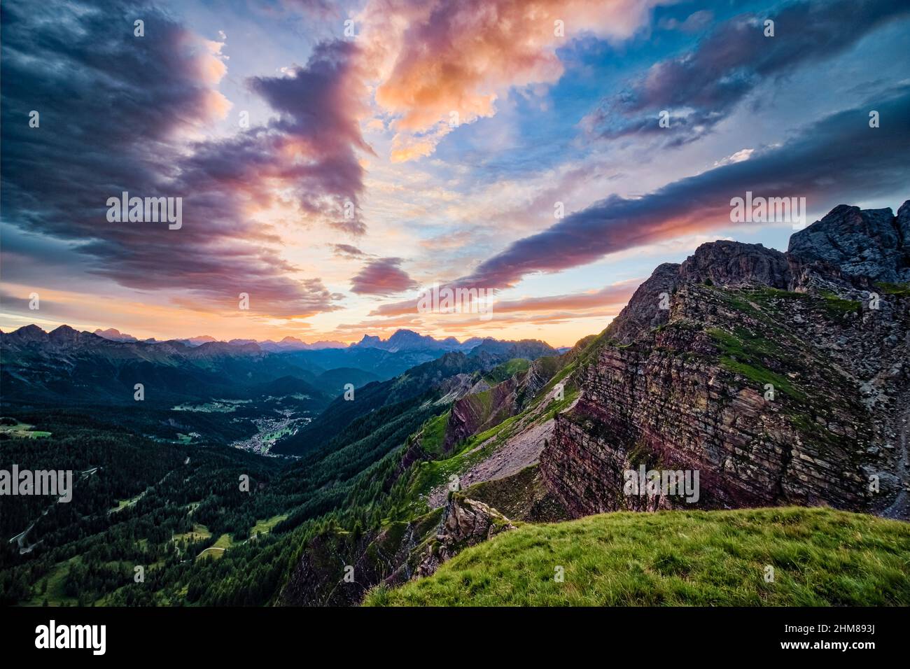 Creste dolomitiche e cime intorno a Falcade nella valle del Biois, Monte Pelmo (a sinistra) e Civetta in lontananza, visto dall'alto del Passo delle Valles al sole Foto Stock
