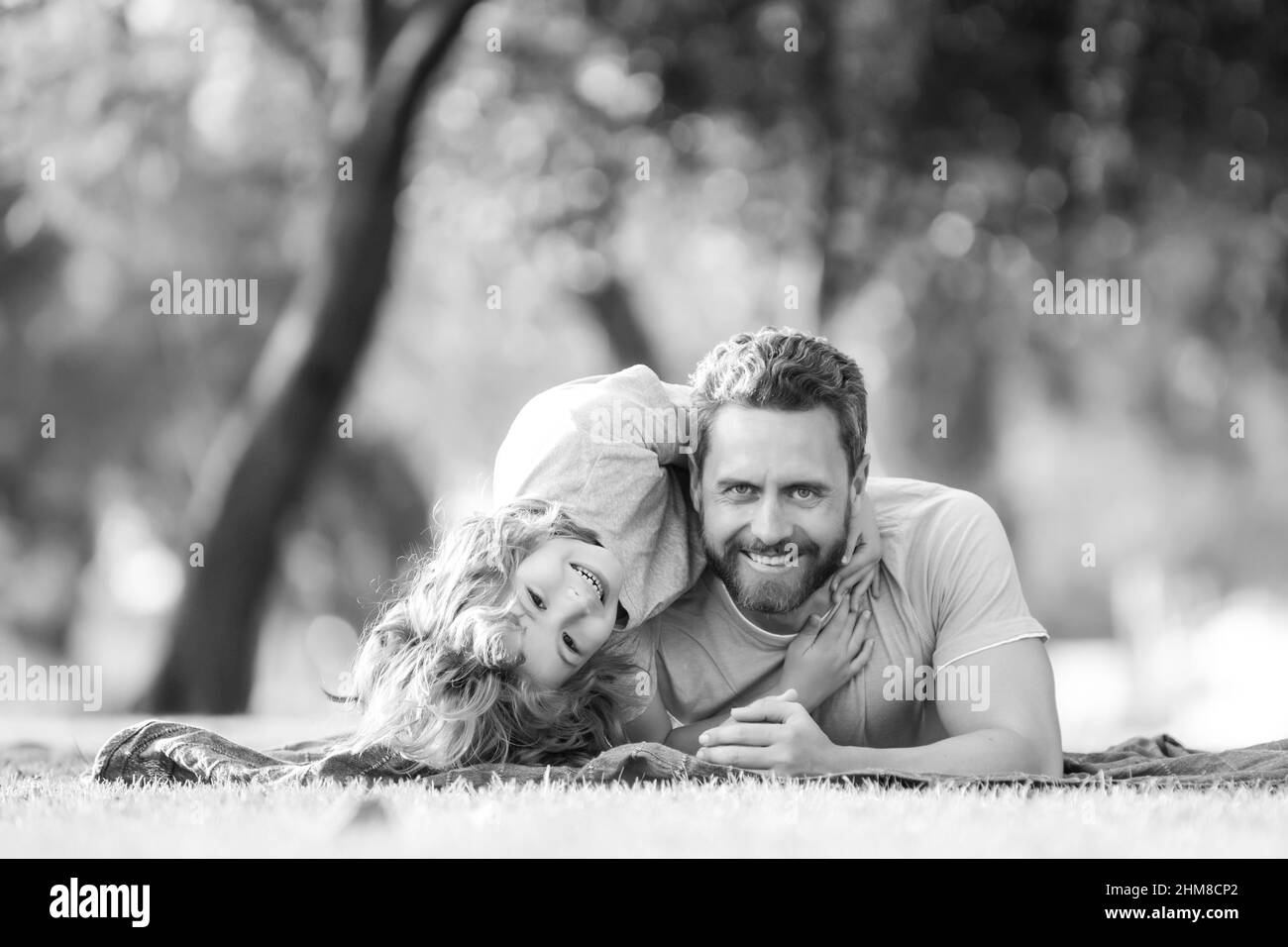 Concetto di bambino di infanzia e di paternità. Felice padre e figlio che giocano insieme all'aperto. I bambini amano i genitori, l'affetto e la tenerezza, la famiglia bella. Foto Stock