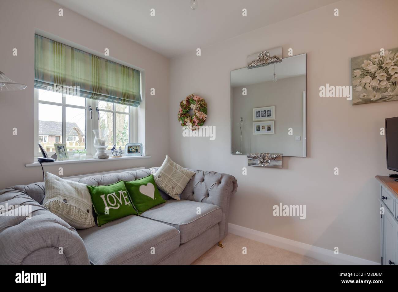 Clare, Suffolk - Marzo 1 2017: Soggiorno compatto o sala tv all'interno di una piccola casa moderna ed elegante con divano e grande specchio Foto Stock