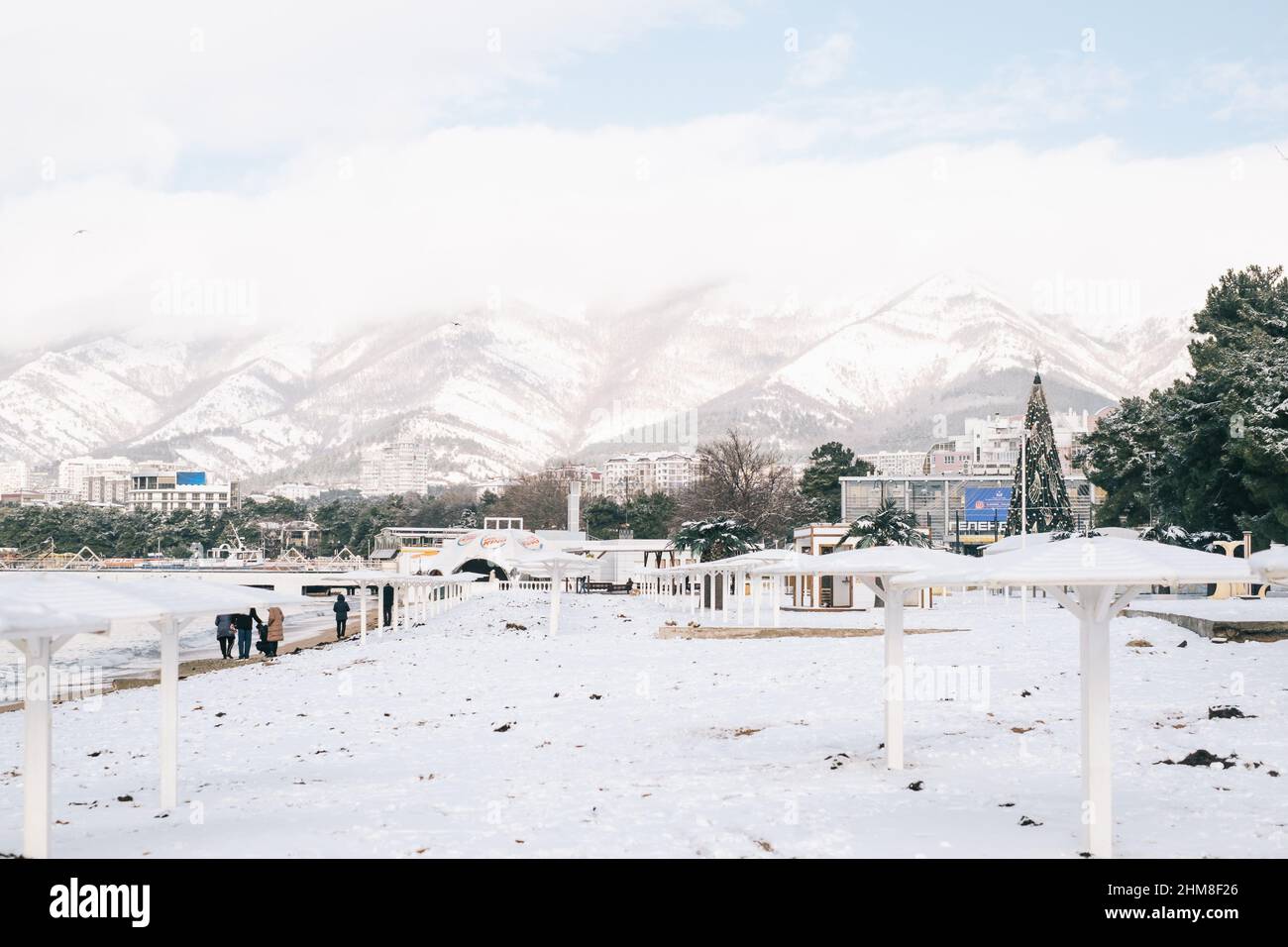 Paesaggio cittadino della spiaggia centrale durante una nevicata con vista sulla catena Markotkh. Foto Stock