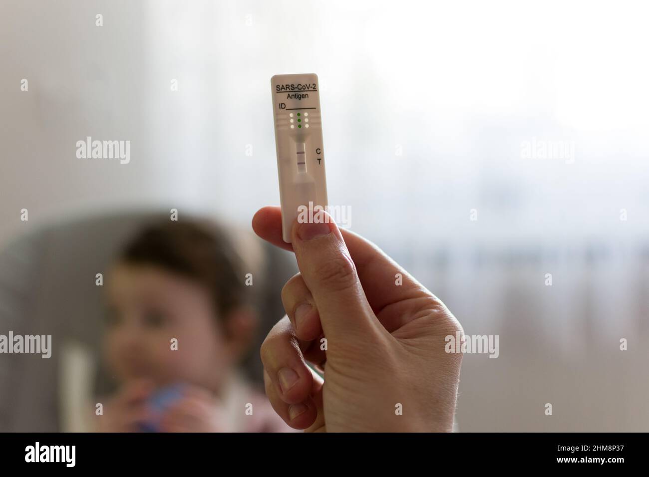 Test rapido dell'antigene corona positivo con la mano in background. Bambino, bambini che testano e vaccina concetto Foto Stock