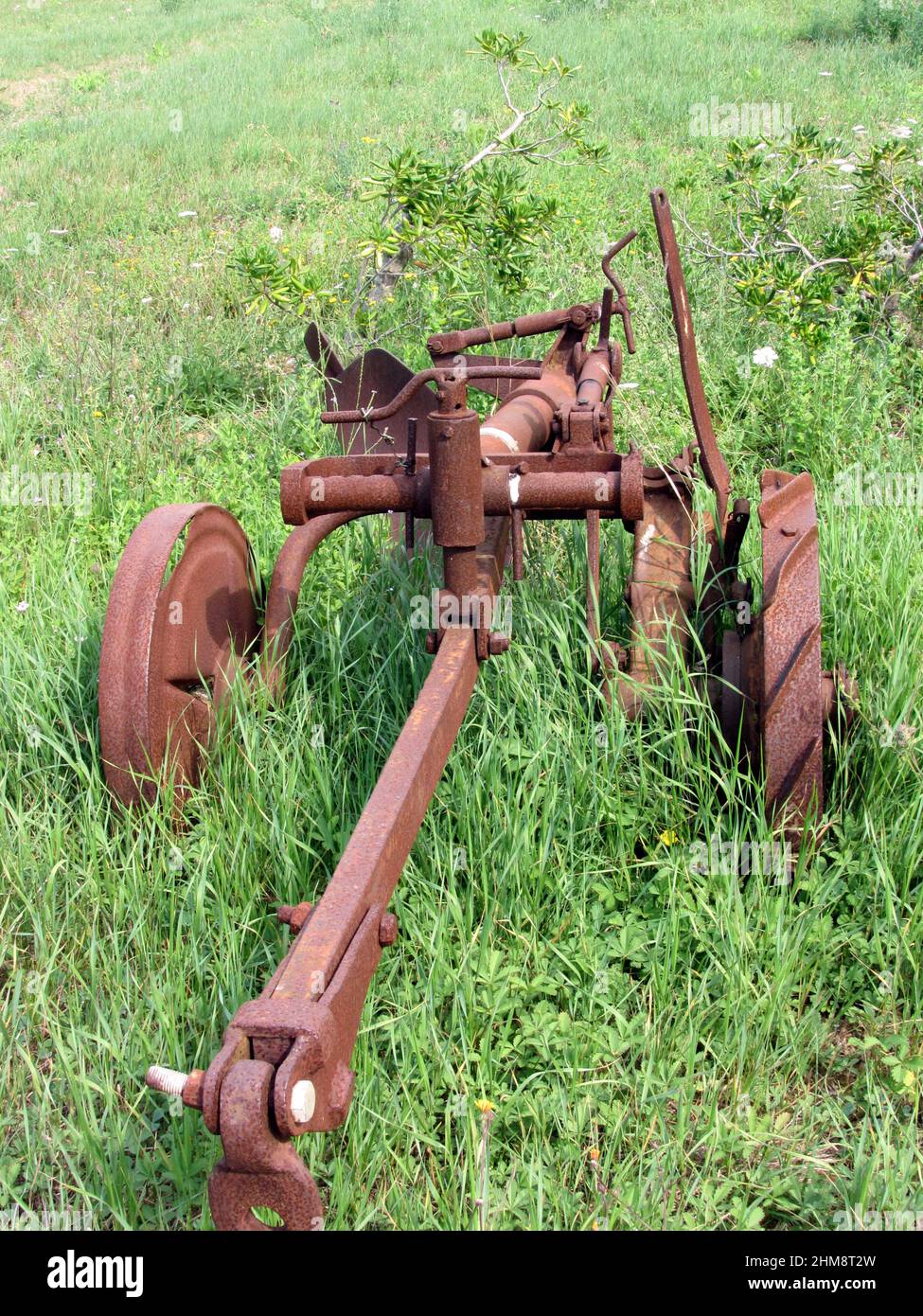 Vecchio aratro arrugginito nel giardino Foto Stock