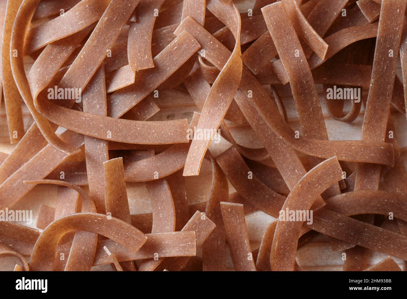 Tagliatelle integrali come struttura di fondo full frame, pasta sana con fibra, proteine, vitamine e minerali B, vista dall'alto dall'alto, sele Foto Stock