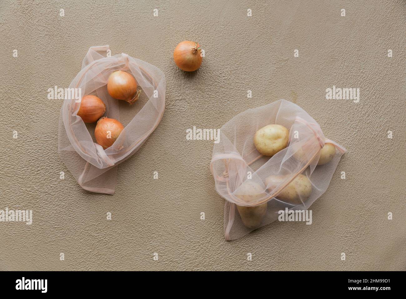 Vista dall'alto della borsa ecologica con coulisse con cipolle e patate. Acquisto senza danni alla natura in sacchetti di plastica. Pacchetti ECO. Zero sprechi. Foto Stock