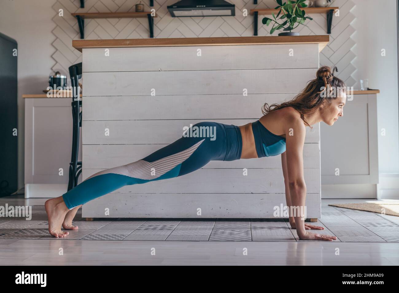 Fit donna che fa full Plank esercizio opere sui muscoli addominali, che si allenano a casa. Foto Stock