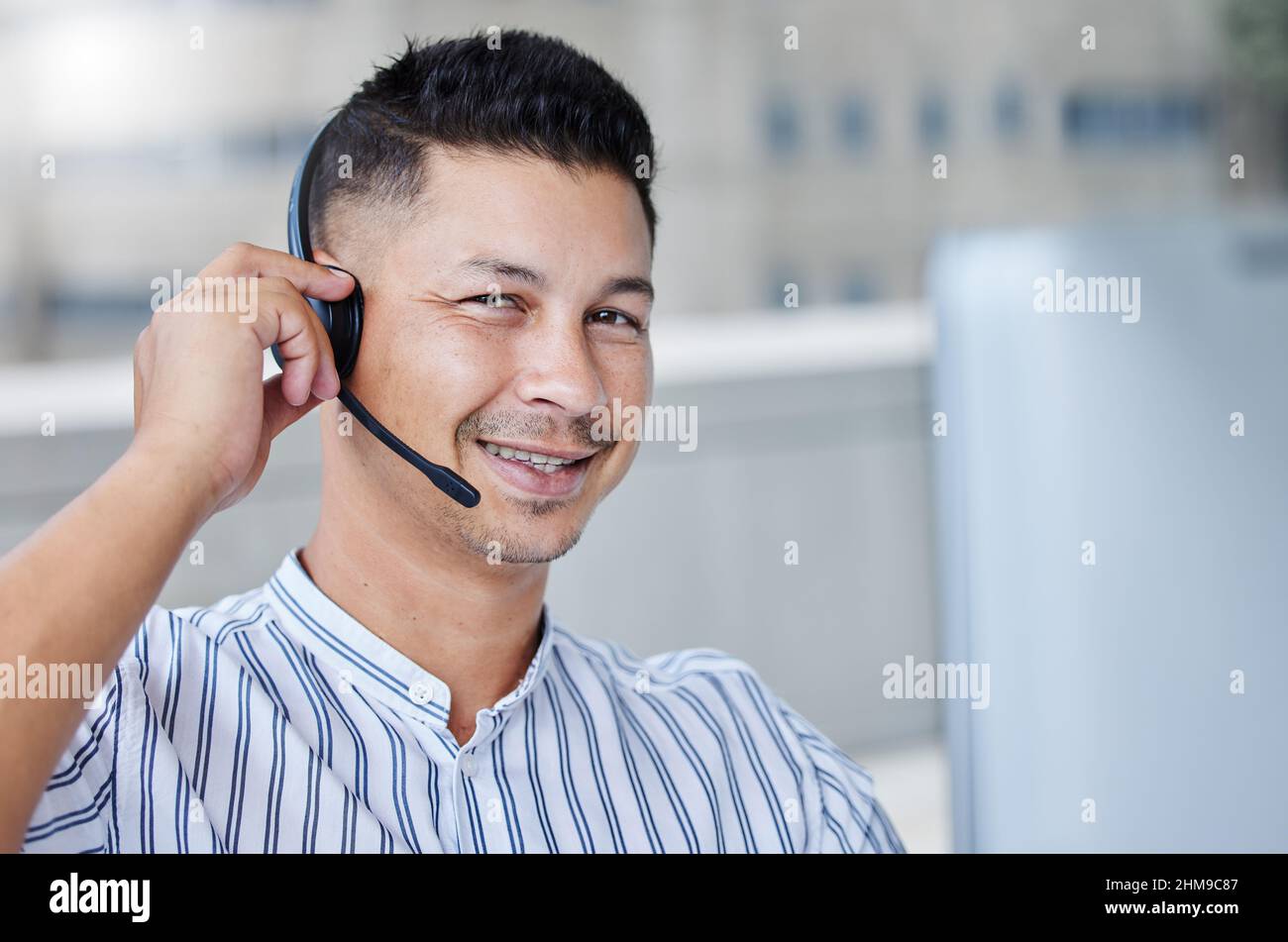 Sì, dovremmo essere in grado di gestire questo Non c’è problema. Scatto di un giovane uomo d'affari che lavora in un ufficio del call center che aiuta un cliente. Foto Stock