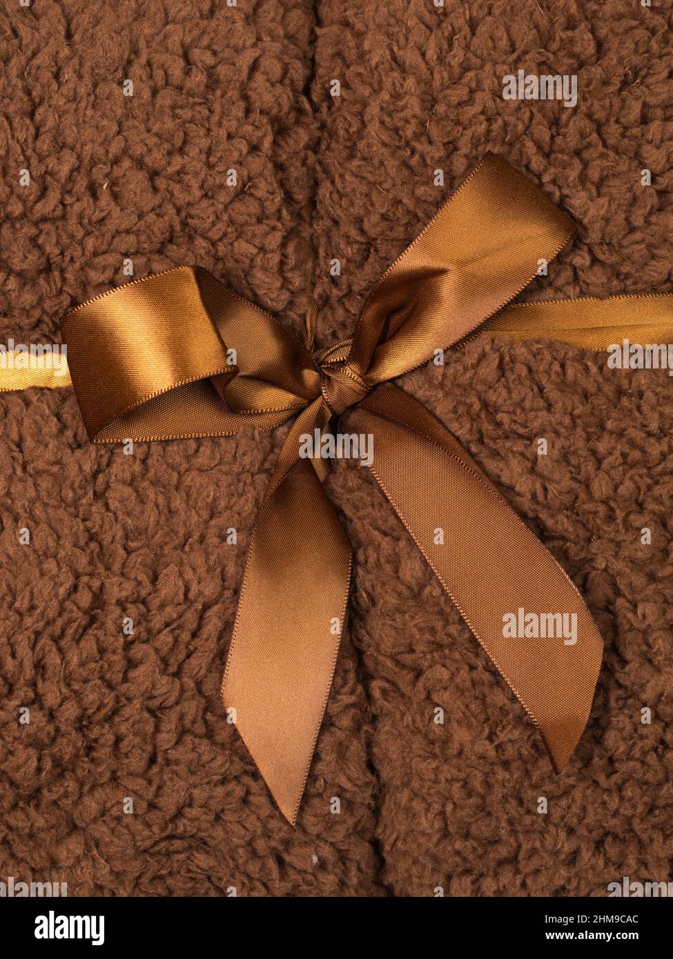 Macro shot full frame di soffice coperta marrone avvolta con nastro serico marrone Foto Stock