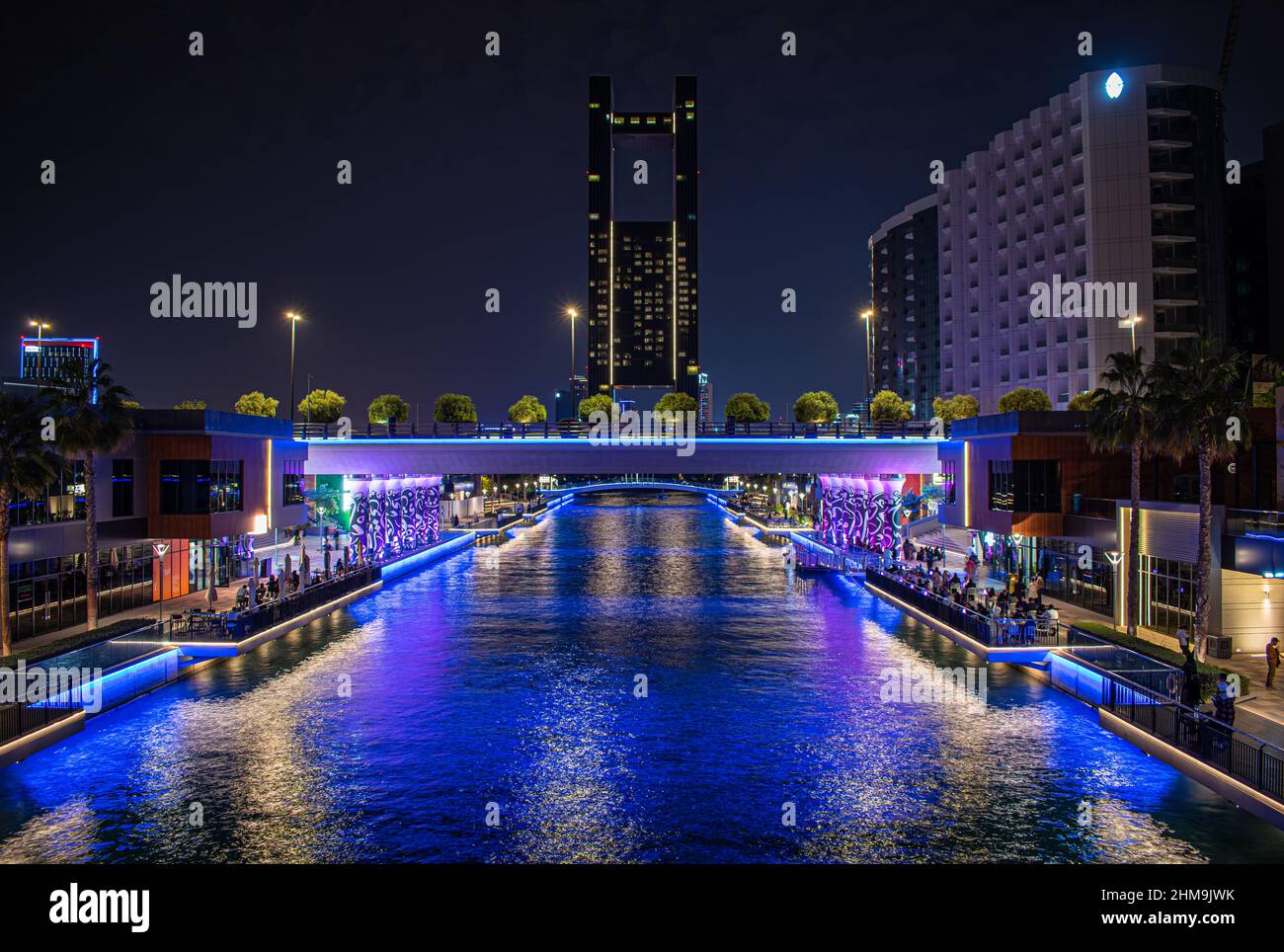 Ammira il Wharf presso Bahrain Bay, che mostra i caffè, i ristoranti e le aree all'aperto illuminate per goderti l'intrattenimento notturno. Foto Stock