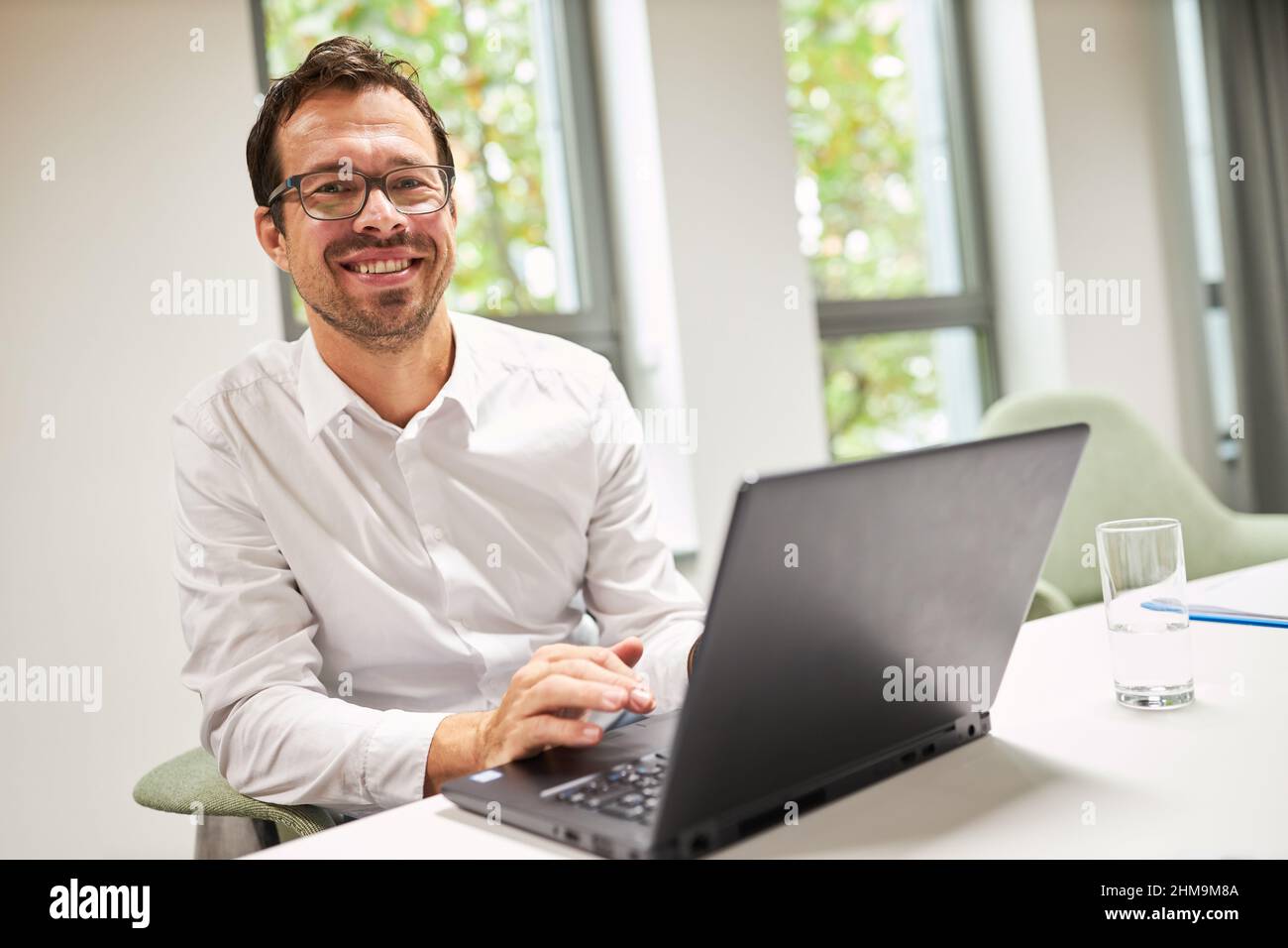 Happy businessman lavora come programmatore su computer portatile online in ufficio Foto Stock