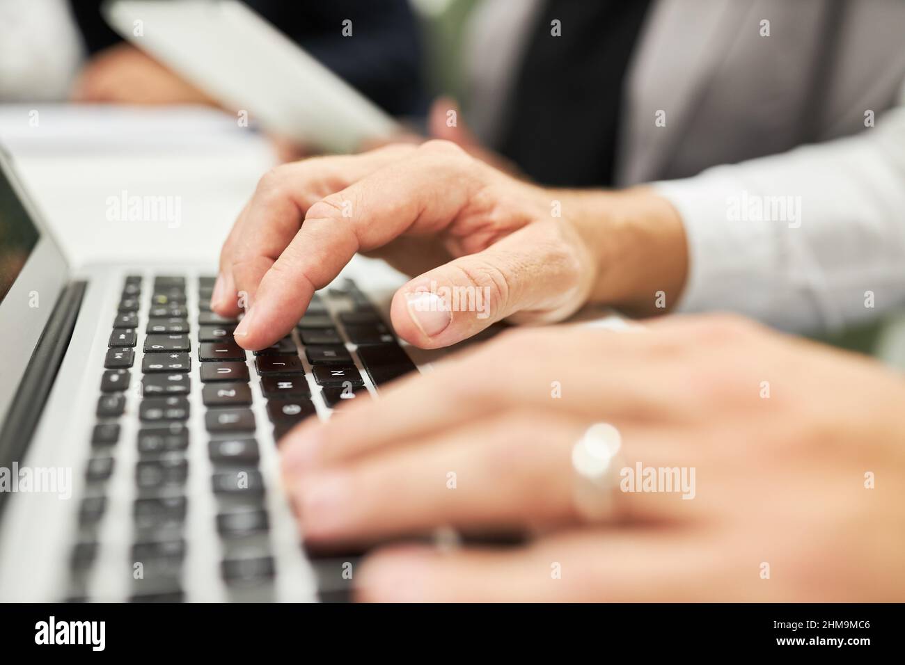 Le mani del uomo d'affari che programmano o digitano sulla tastiera del calcolatore in ufficio Foto Stock