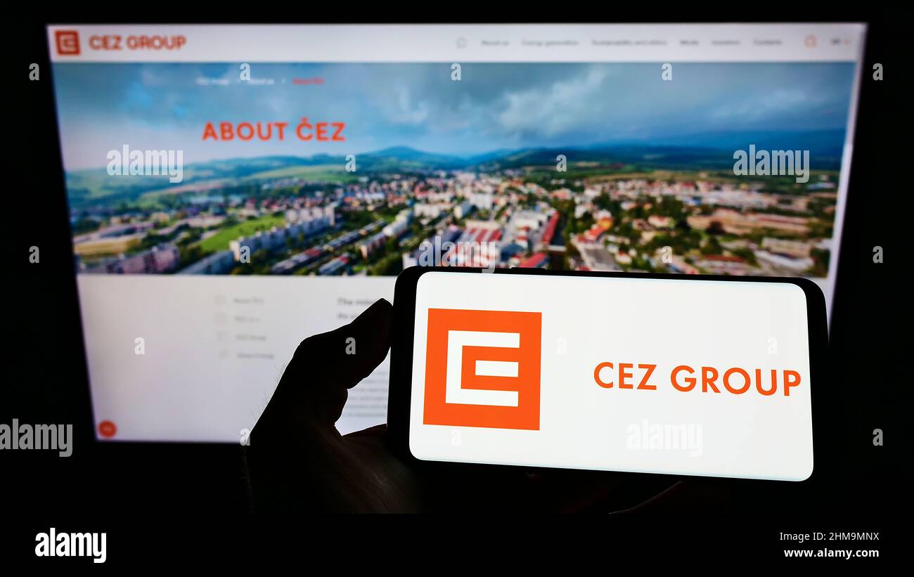 Persona che tiene uno smartphone con il logo dell'azienda energetica ceca CEZ a.s. sullo schermo di fronte al sito Web. Mettere a fuoco sul display del telefono. Foto Stock