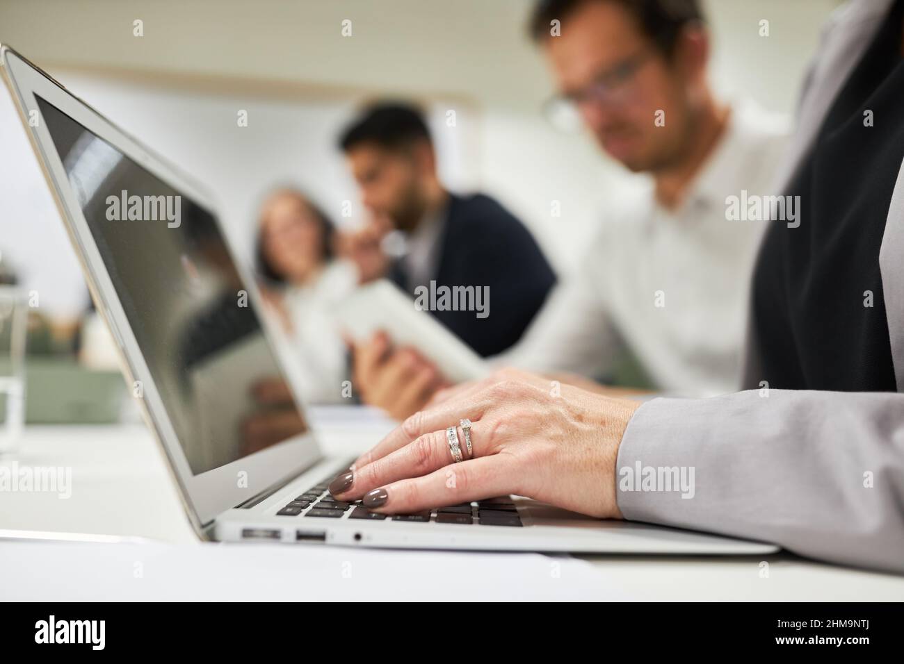 Mano di donna d'affari che digita su un computer portatile in un workshop di informatica o e-learning Foto Stock