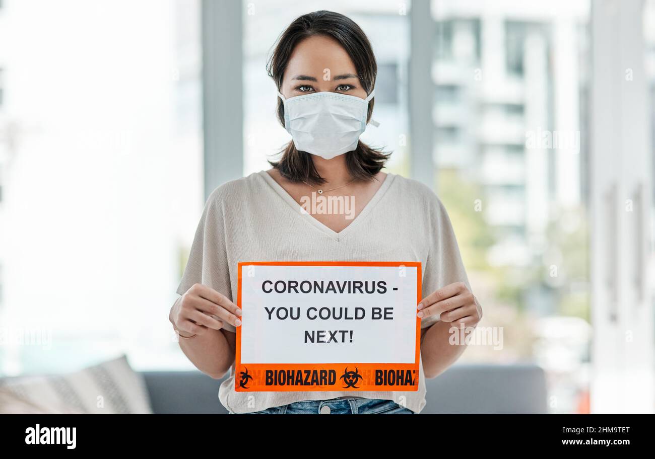 Nessuno è esente. Colpo di una donna che tiene in su un segno che dice CORONAVIRUS - POTRESTE ESSERE SEGUENTE. Foto Stock