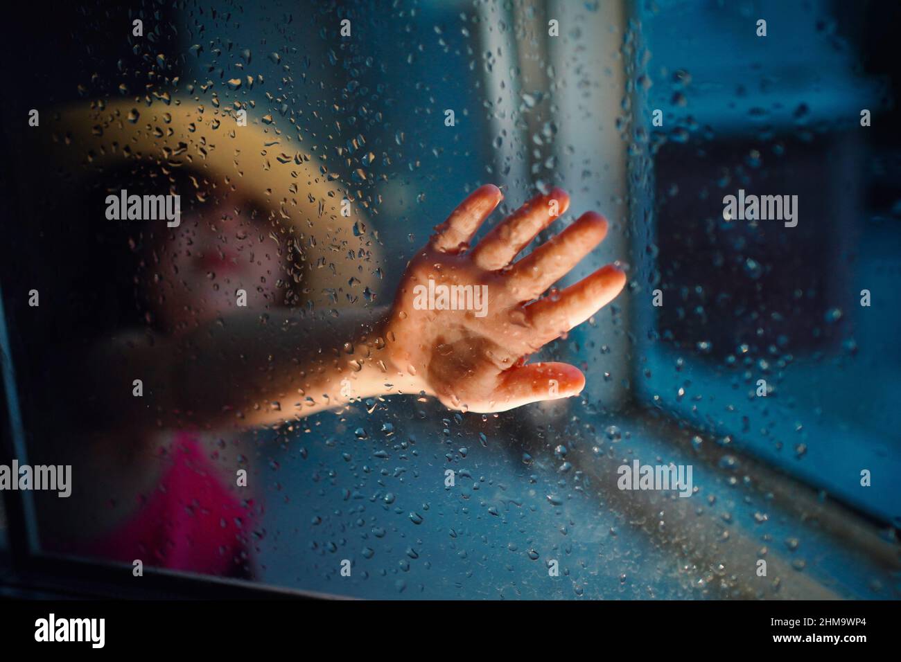 una ragazza in un cappello di paglia, pioggia fuori dalla finestra Foto Stock