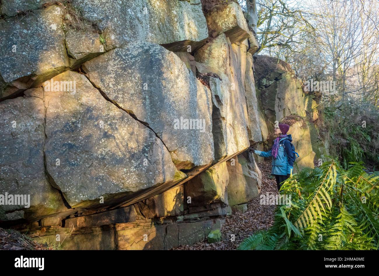 Ispezione di una parete di pietra arenaria rossa con intemperie nella cava di Cowraik (disutilizzata), Penrith, Cumbria Foto Stock