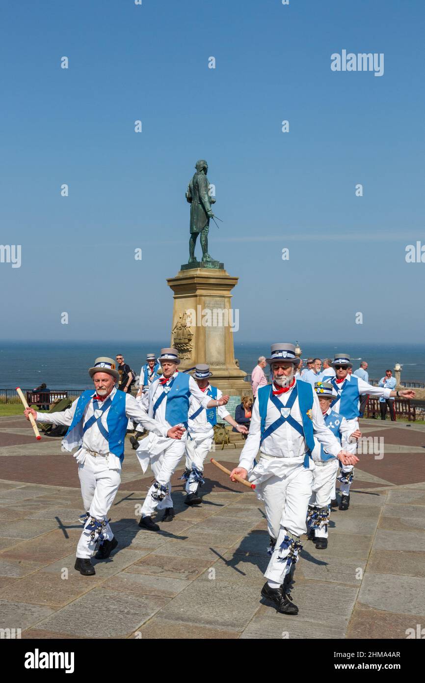 Ballerini Morris alla settimana folk di Whitby con la statua del Capitano Cook Foto Stock