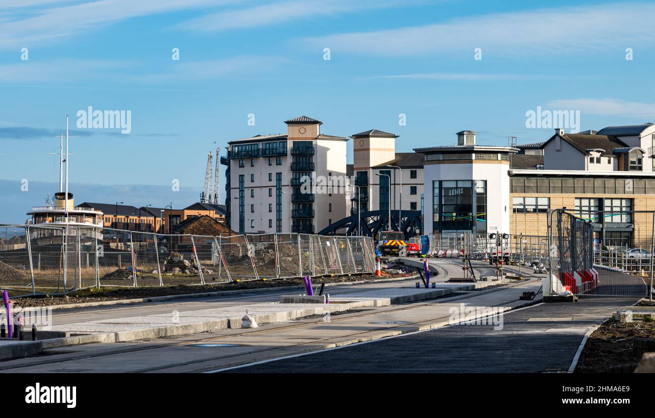 Leith, Edimburgo, Scozia, Regno Unito, 8th febbraio 2022. Tram per la costruzione di Newhaven: Mentre il progetto principale si avvicina al suo ultimo anno, con i lavori in programma e che dovrebbe essere completato nella primavera del 2023 entro il suo bilancio di £ 207,3m, numerose strade sono chiuse al traffico a Leith. Oltre il 60% dei binari è stato posato (2,8km) e il 85% delle deviazioni sono state effettuate. Nella foto: I binari del tram su Ocean Drive con l'hotel galleggiante Fingal Foto Stock