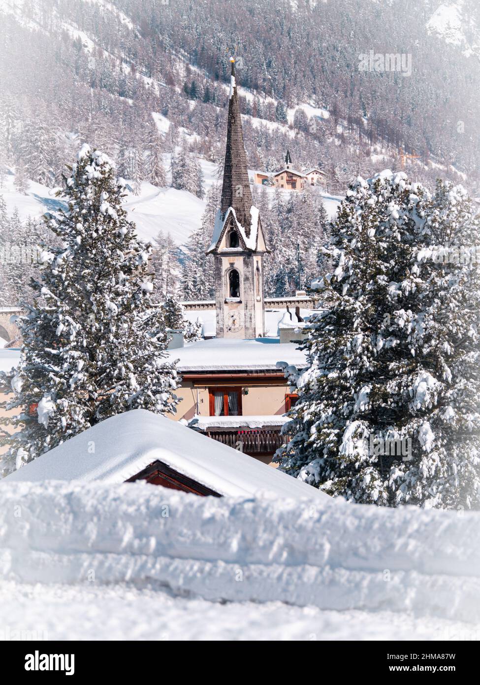 Cinuos-Chel, Svizzera - 3 febbraio 2022: Vista invernale presso un campanile della chiesa protestante riformata in un villaggio innevato di Cinuos Chel in Eng Foto Stock