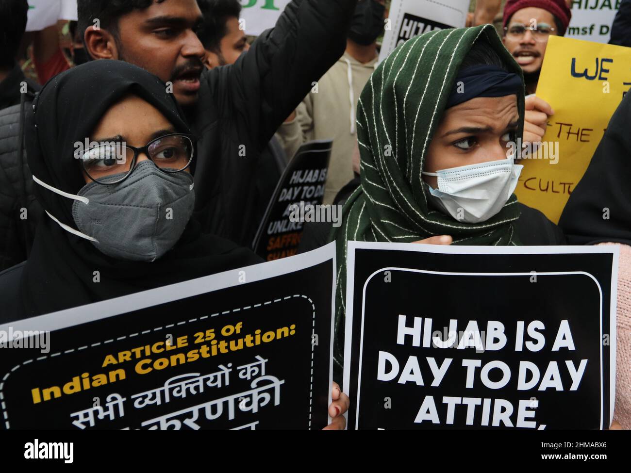 Gli attivisti studenteschi musulmani indiani che indossano facemasks tengono dei cartelli durante una protesta sotto la bandiera della federazione studentesca musulmana (MSF), al di fuori della facoltà di arte dell'Università di Delhi. Nello stato di Karnataka in India, la controversia è iniziata il mese scorso quando gli studenti musulmani sono stati sbarrati dalle classi per aver indossato hijab. A causa della protesta per la polemica hijab, il ministro capo di Karnataka tweet che tutte le scuole superiori, college saranno chiusi per i prossimi 3 giorni per mantenere la pace e l'armonia. (Foto di Naveen Sharma / SOPA Images/Sipa USA) Foto Stock