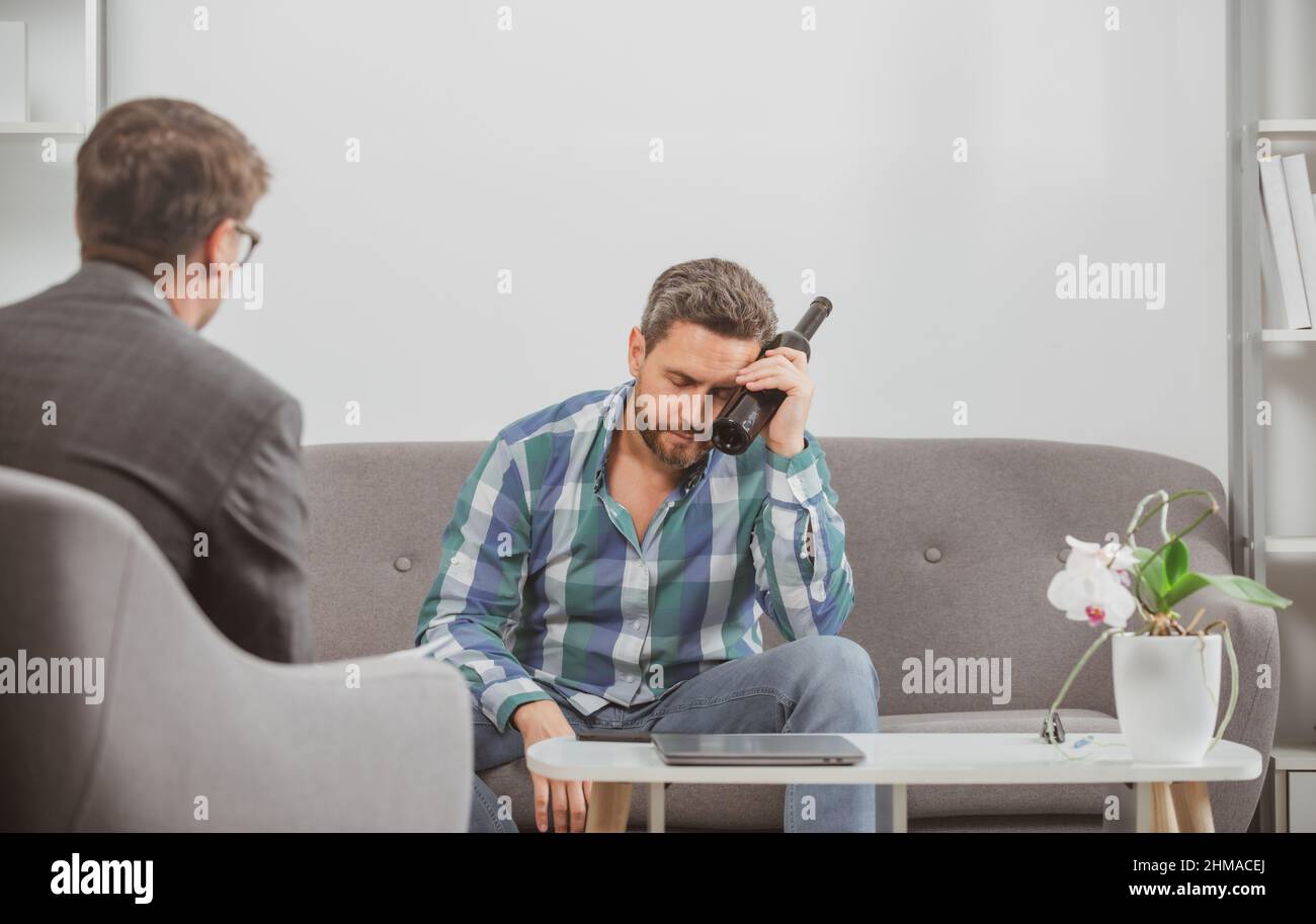 Terapia psicologa per il giovane, psicologia. Uomini ubriachi tristi, solitari e disperati nel dolore e nello stress emotivo. Persone e abuso di alcol, dipendenza. Foto Stock