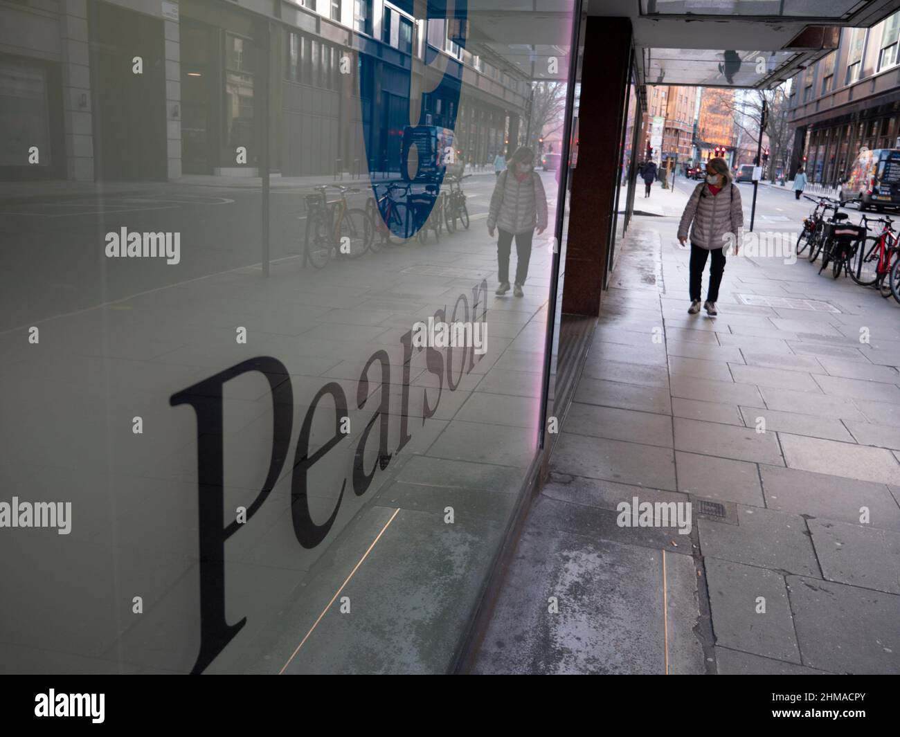 Pendolari che passano accanto alla sede centrale della società di formazione Pearson nel centro di Londra, Pearson plc è un'azienda britannica di editoria e formazione con uffici a Londra. Foto Stock