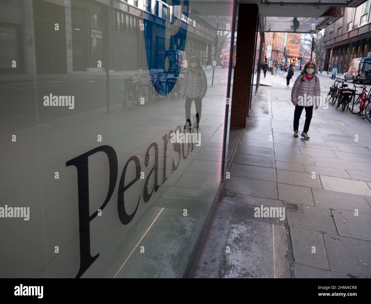 Pendolari che passano accanto alla sede centrale della società di formazione Pearson nel centro di Londra, Pearson plc è un'azienda britannica di editoria e formazione con uffici a Londra. Foto Stock