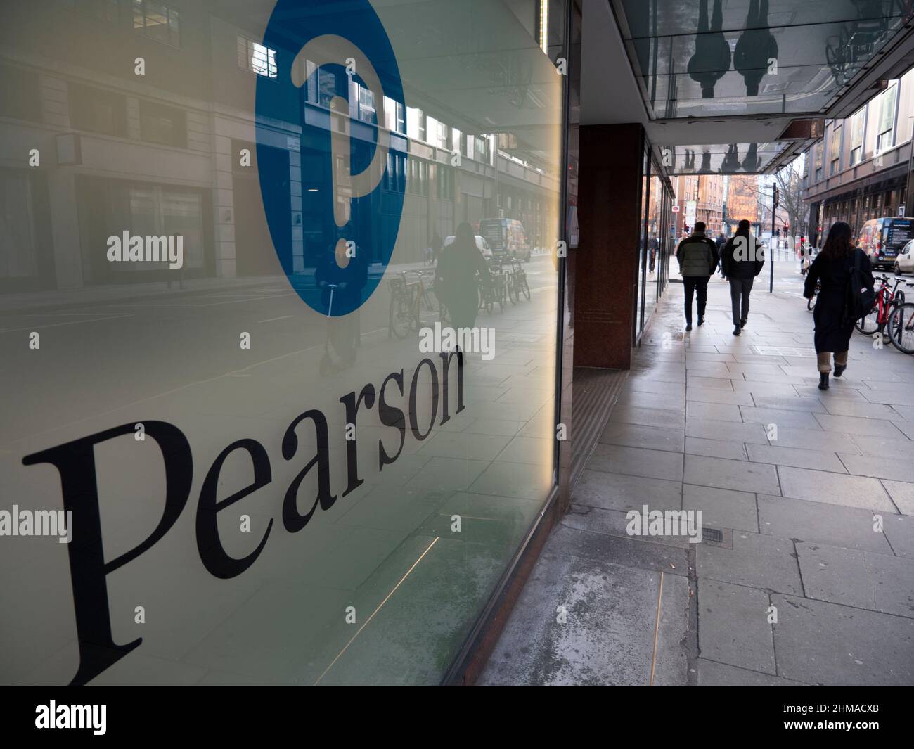 Pendolari che passano accanto alla sede centrale della società di formazione Pearson nel centro di Londra, Pearson plc è un'azienda britannica di editoria e formazione con uffici a Londra. Foto Stock