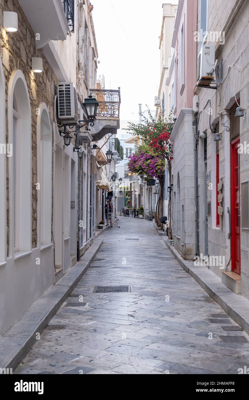 Grecia. Ermoupolis Syros, capitale delle Cicladi, strada lastricata in pietra, architettura tradizionale e bougainvillea pianta Foto Stock